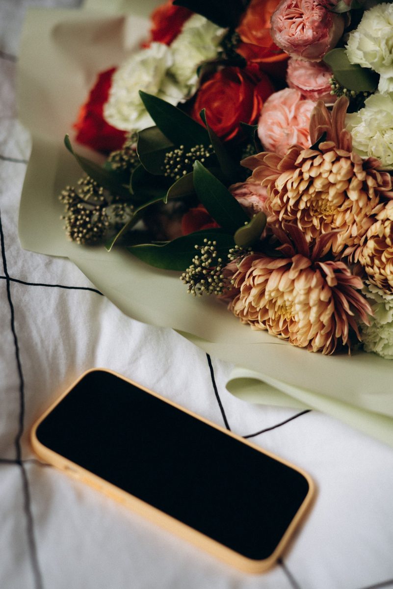 Fresh flower bouquet beside a smartphone